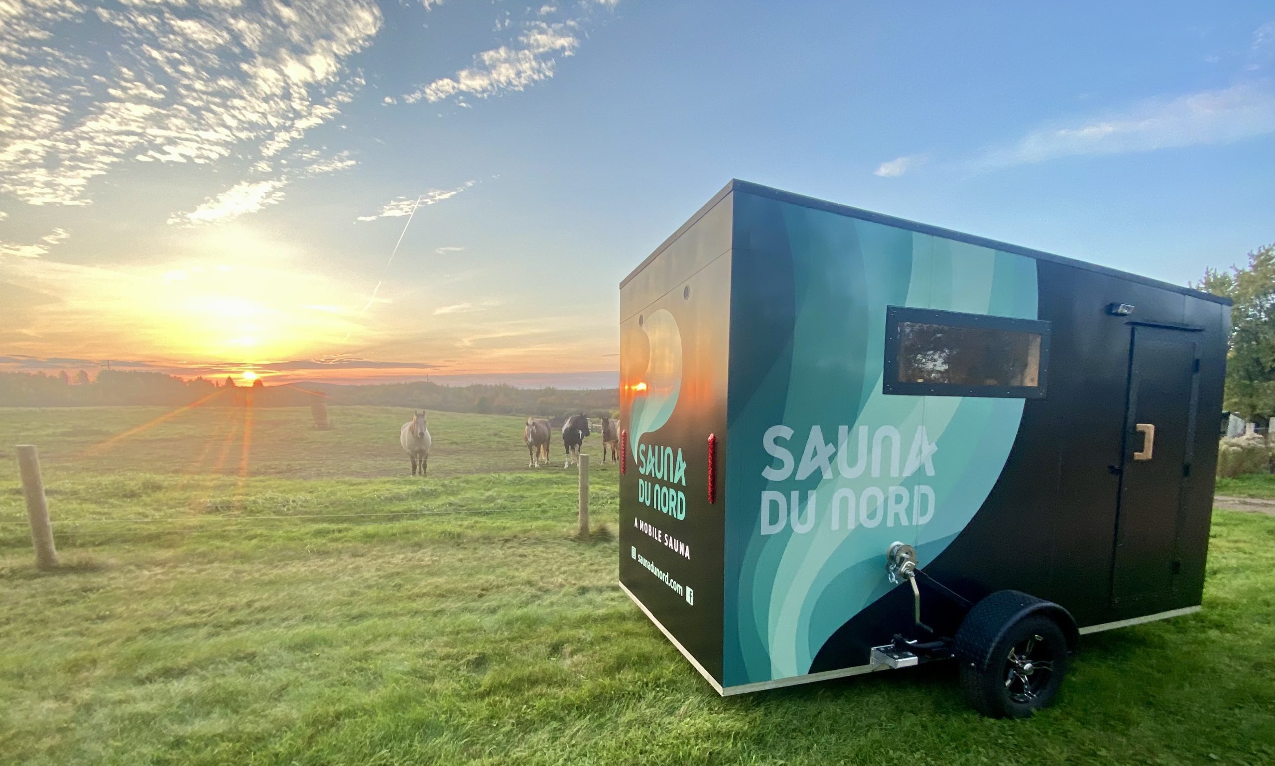 sauna du nord mobile sauna by sunrise and horses in pastoral setting